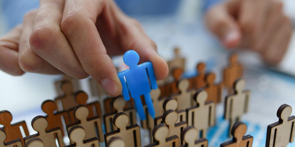Hand selecting a blue person figure.